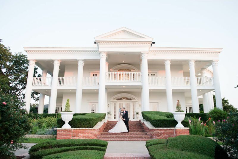 bride and groom outside mansion