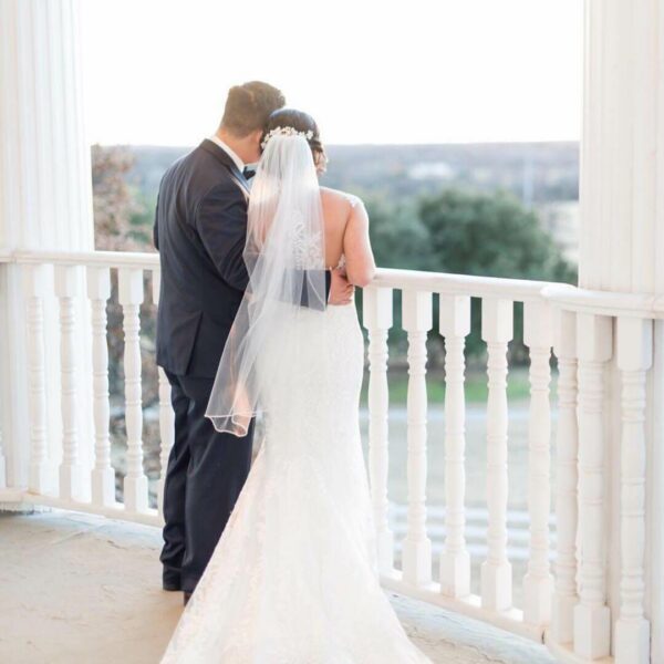 bride and groom up on the mansion balcony