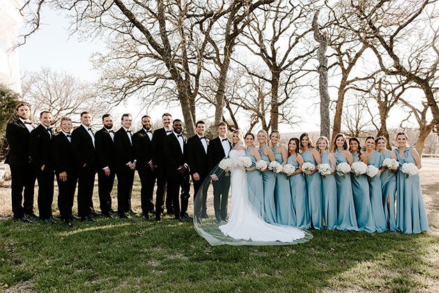 wedding party posing in front of trees