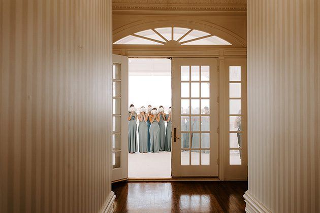 bridal party outside doors waiting for bride