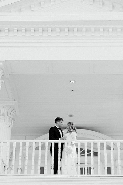 bride and groom on mansion balcony